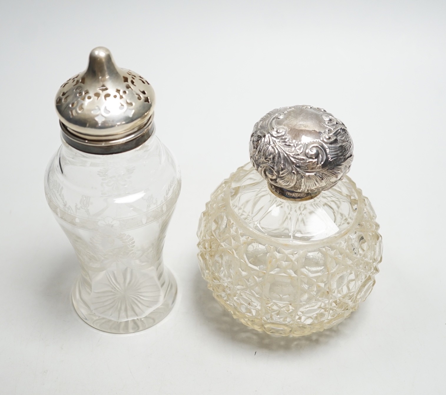 A late Victorian repousse silver mounted cut glass scent bottle, Chester, 1900, 13cm and a silver mounted sugar caster.